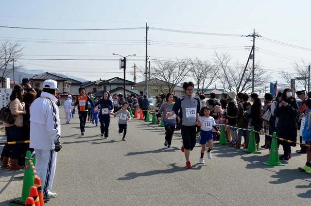 (写真)仲良く手をつないでゴールを目指す親子たち