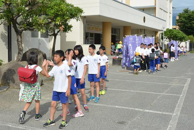 竜王小学校にて小学児童が登校の際に中学生たちがあいさつ運動をしている写真
