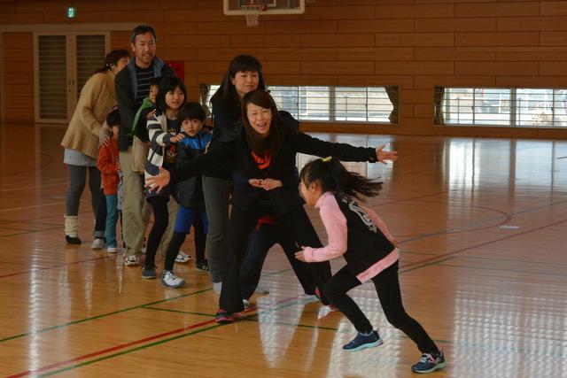 人々が列になり、一人の女の子がそれに向かって走る写真