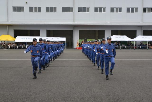 (写真)訓練礼式で縦一列に行進する団員
