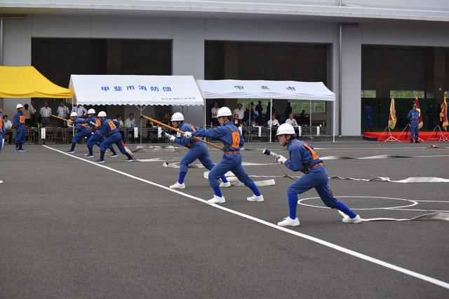 (写真)ポンプ車操法にて横一列に並び放水をしようとする団員