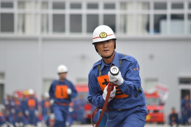 (写真)小型ポンプ操法にて放水をしようとする団員
