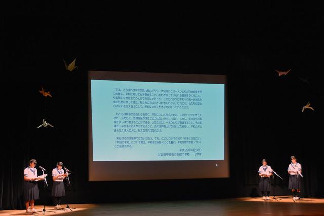 壇上で4人の女子学生がマイクの前に立っている写真