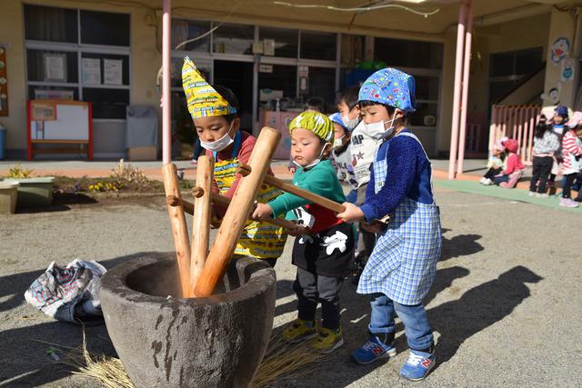 3人で一緒に餅つきをしている子供たちの写真
