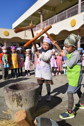 2人で一緒に餅つきをしている子供たちの写真