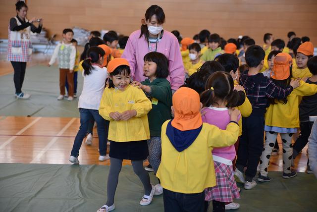 体育館で小学生を遊ぶ園児たちの写真