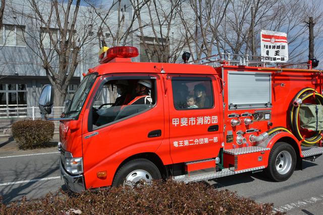 甲斐市消防団フェスタで親子で消防車試乗体験している写真
