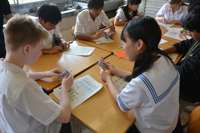 タラマラハイスクールの生徒に竜王中学校の生徒が折り紙を教えている様子の写真