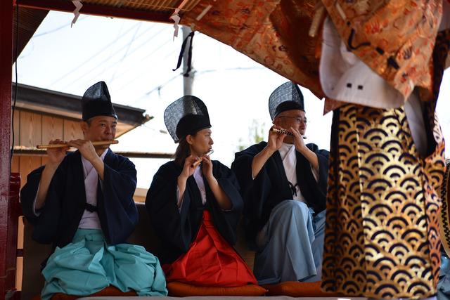 烏帽子をかぶって、笛を吹く三人の男性の写真