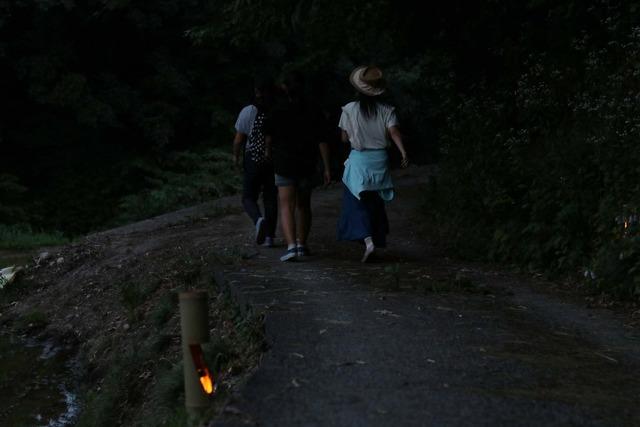 ろうそくの明かりを頼りに歩く人の写真
