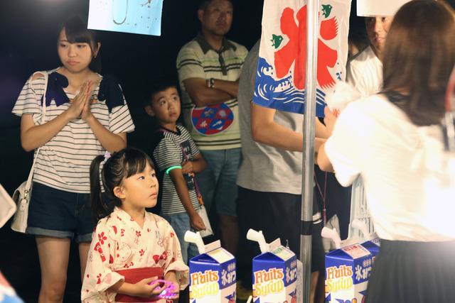 かき氷の露店の前で並んでいる浴衣姿の女の子の写真