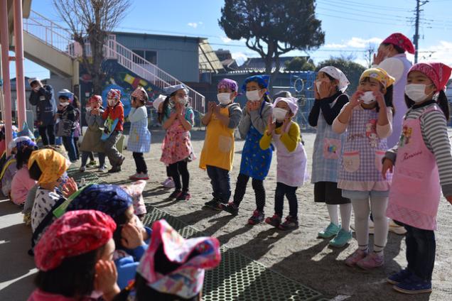 並んで立って餅の手遊びを披露する子供達の写真