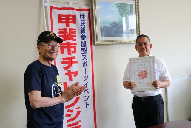 (写真)表彰状をもつ男性と市長