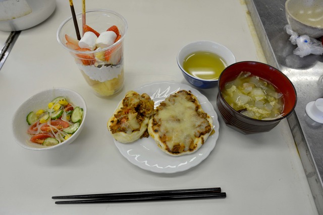 小さいピザ2枚、サラダ、味噌汁、カップパフェとお茶が並んでいる写真