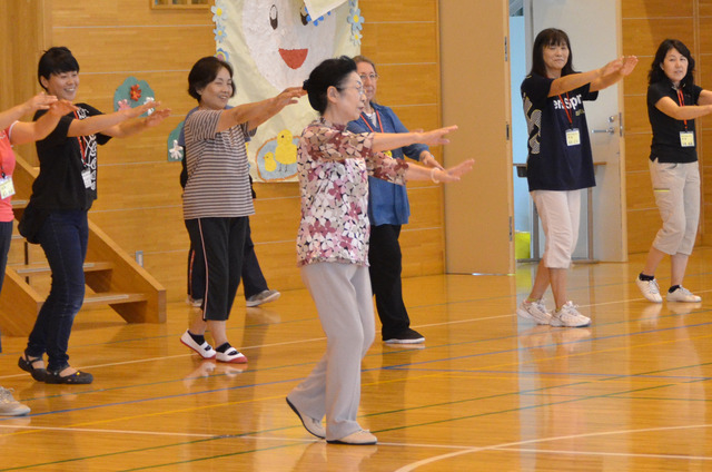 体育館で講習を受ける保護者たちの写真