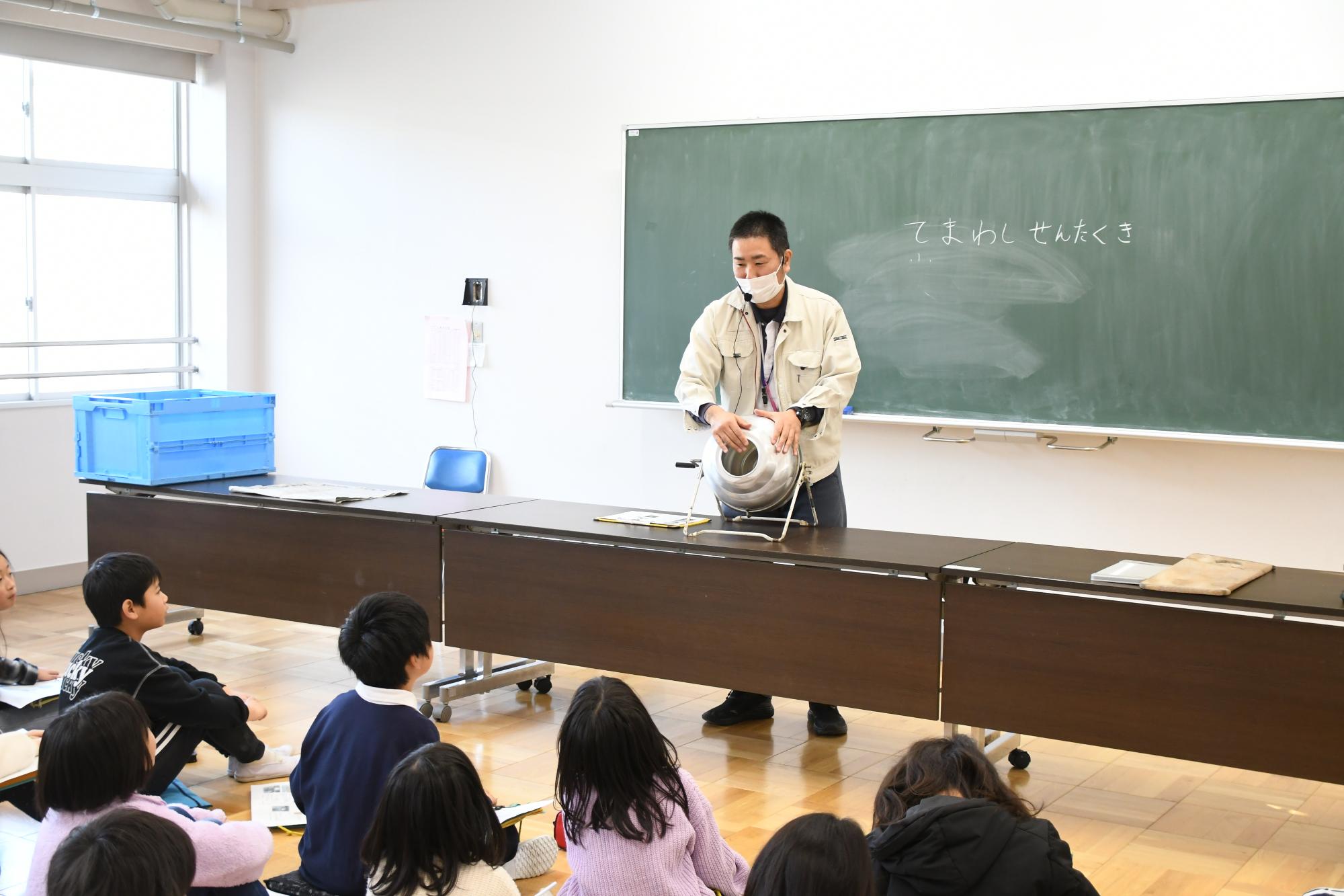 手回し洗濯機の説明をする講師の写真