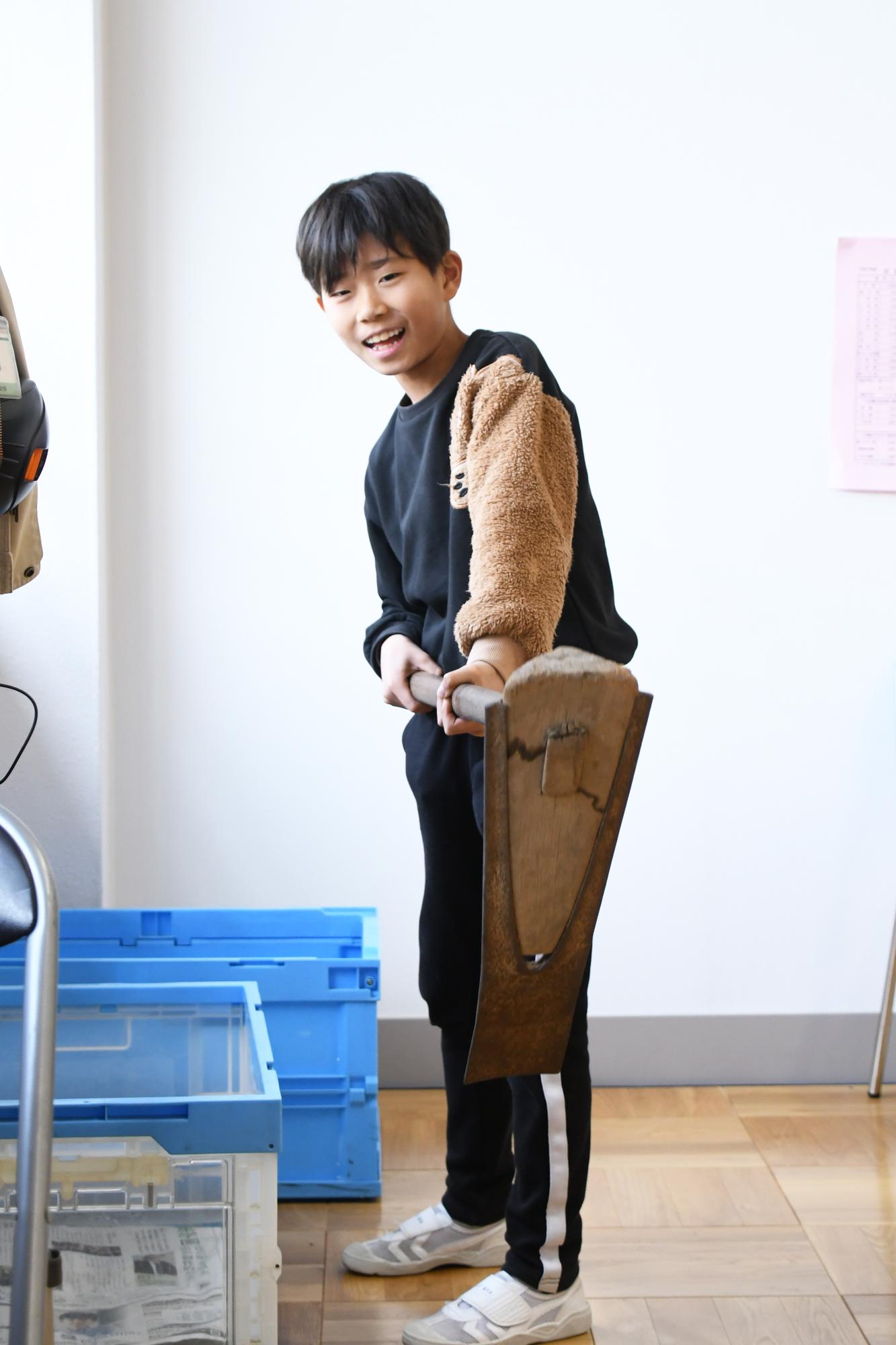 鍬を手に取る児童の写真