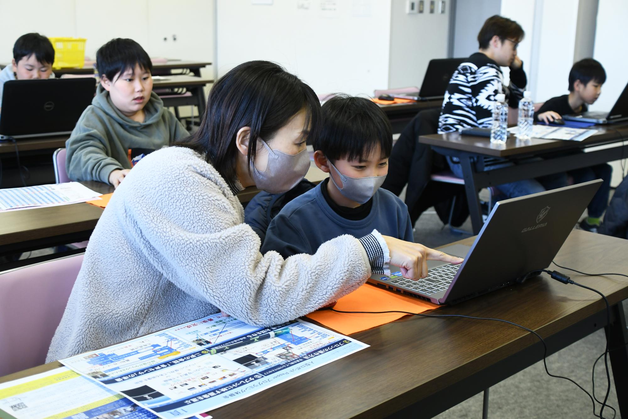 親子で笑顔でパソコンを操作している写真