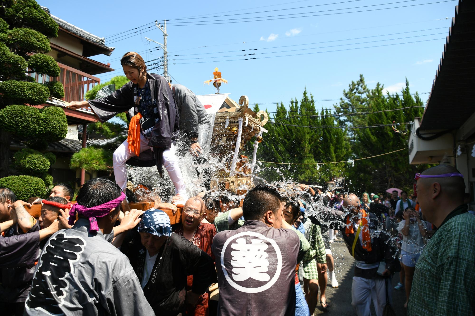 水をかけられながらも神輿を担ぎます