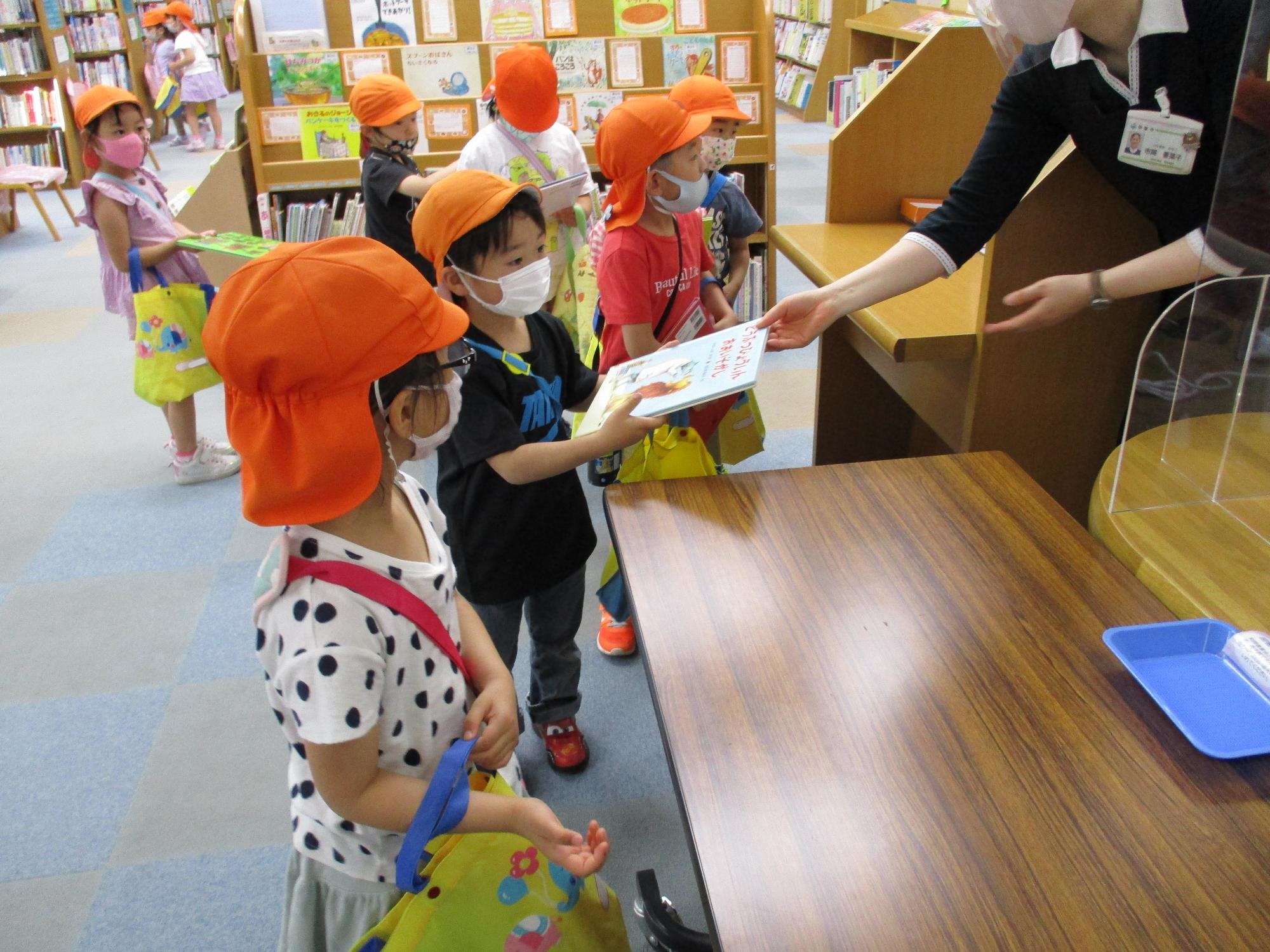 図書館で本を借りるのを楽しむひまわり組の子ども達です。