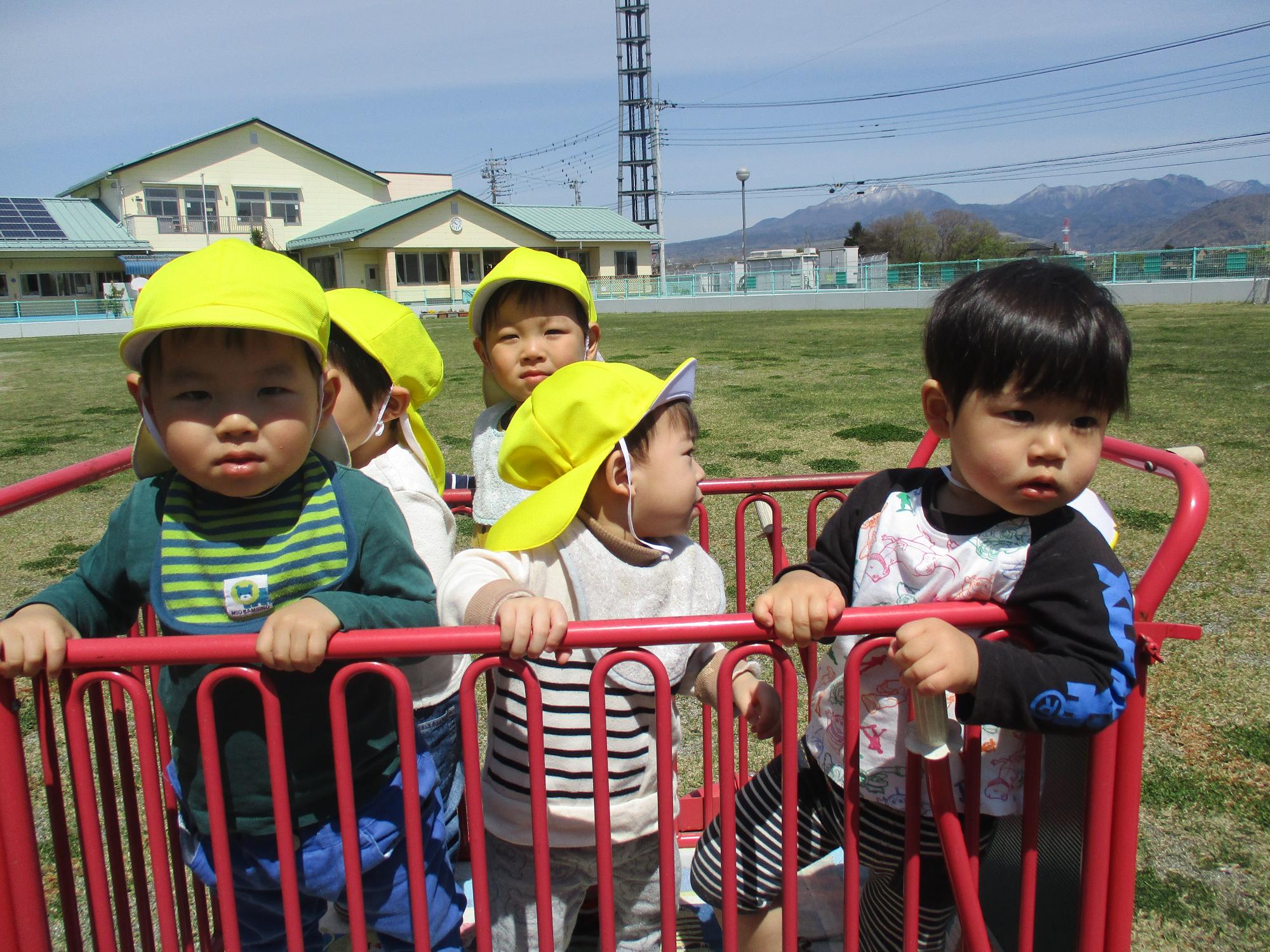 避難者に乗ってお散歩を楽しむつぼみ1組の子供たちです。