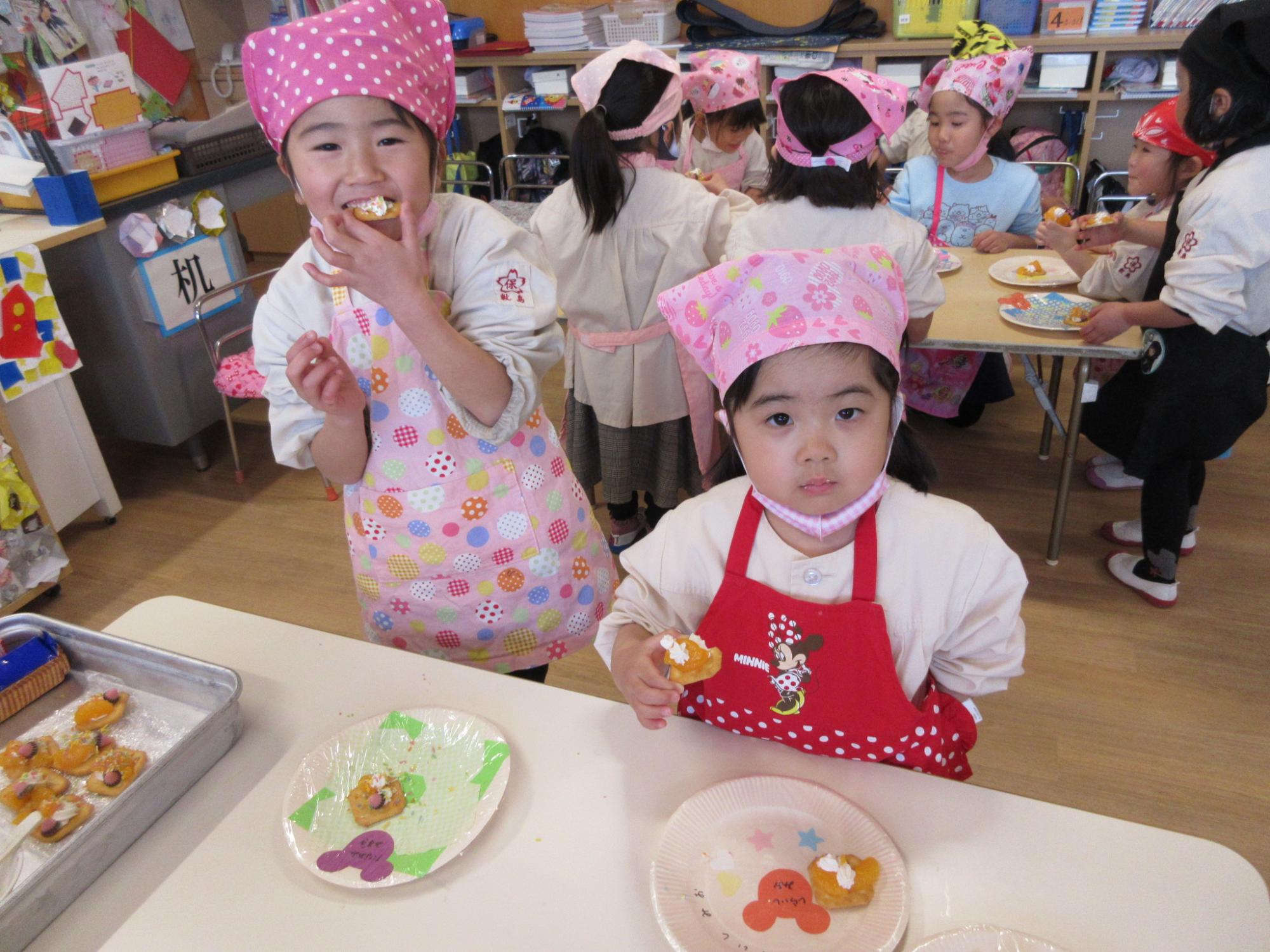 トッピングパーティーで出来上がったお菓子を食べて喜ぶ写真です。