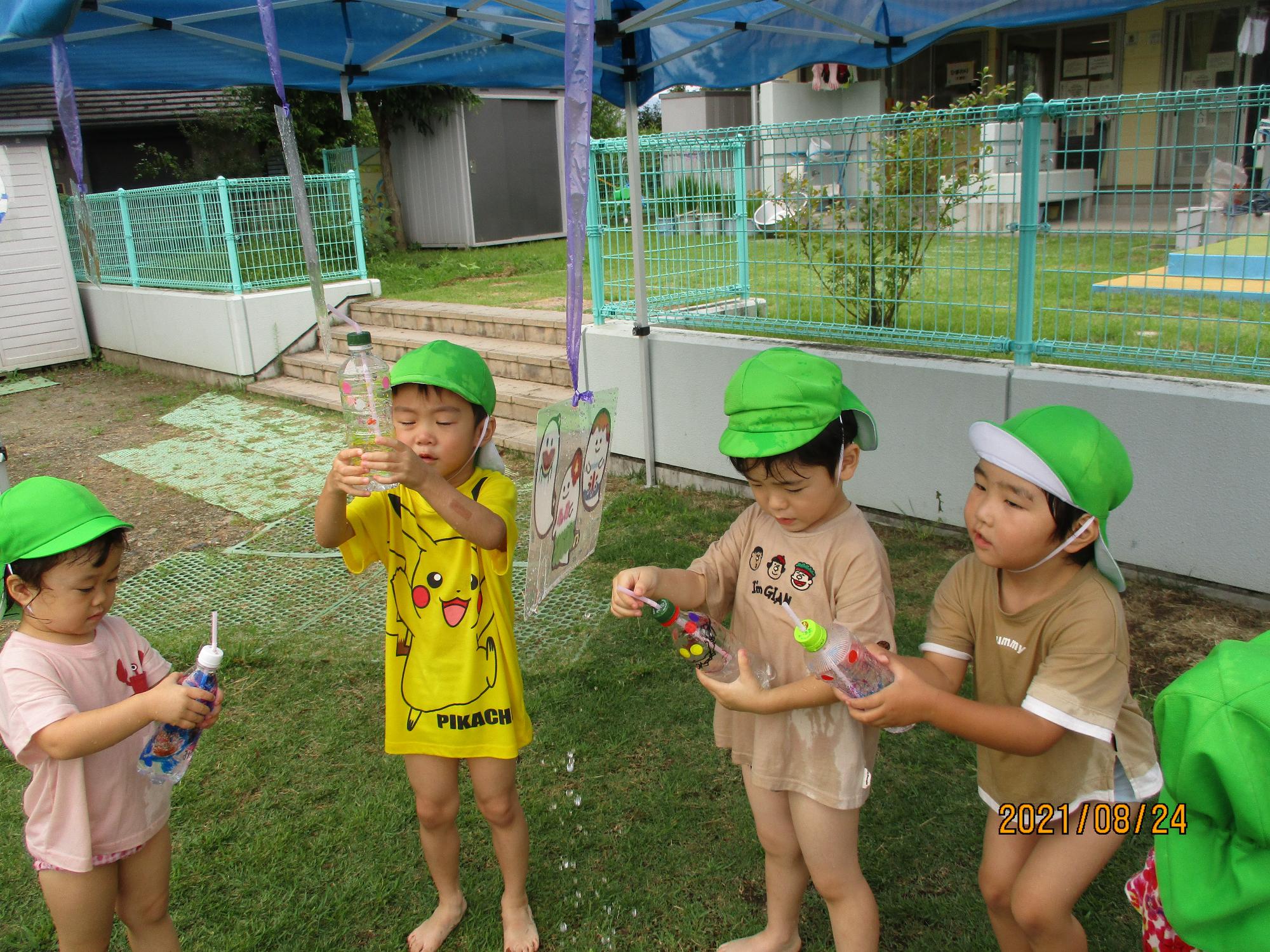 ペットボトルで作った水鉄砲を楽しむすみれ組の子ども達です。