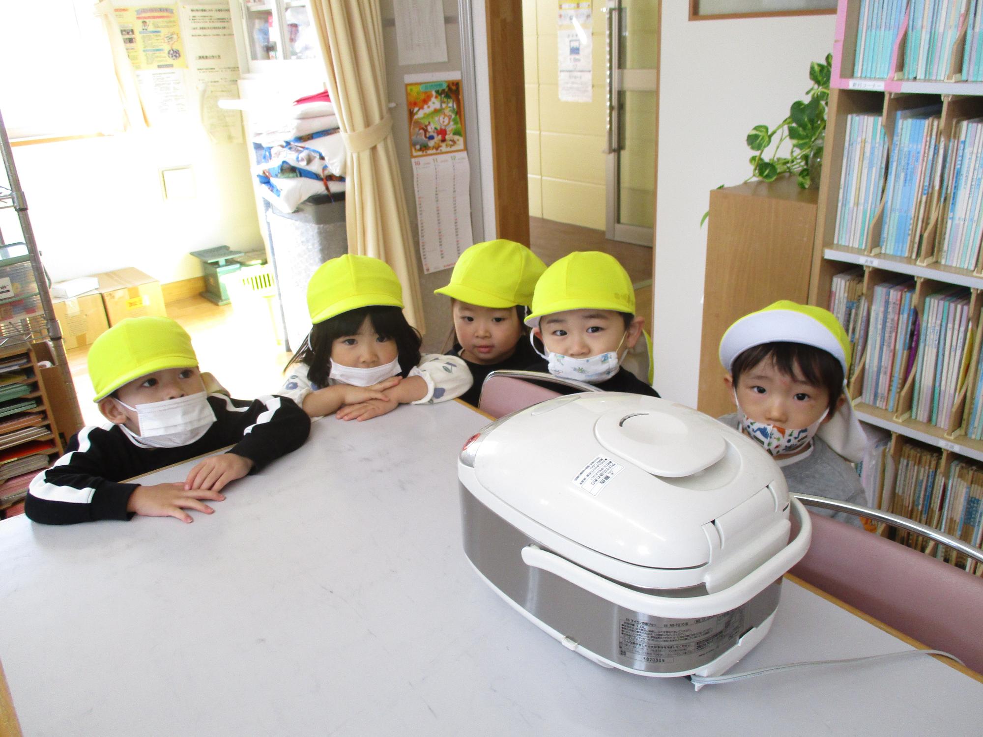 炊飯器を前にご飯が炊ける匂いをかぐつぼみ2組の子ども達です。