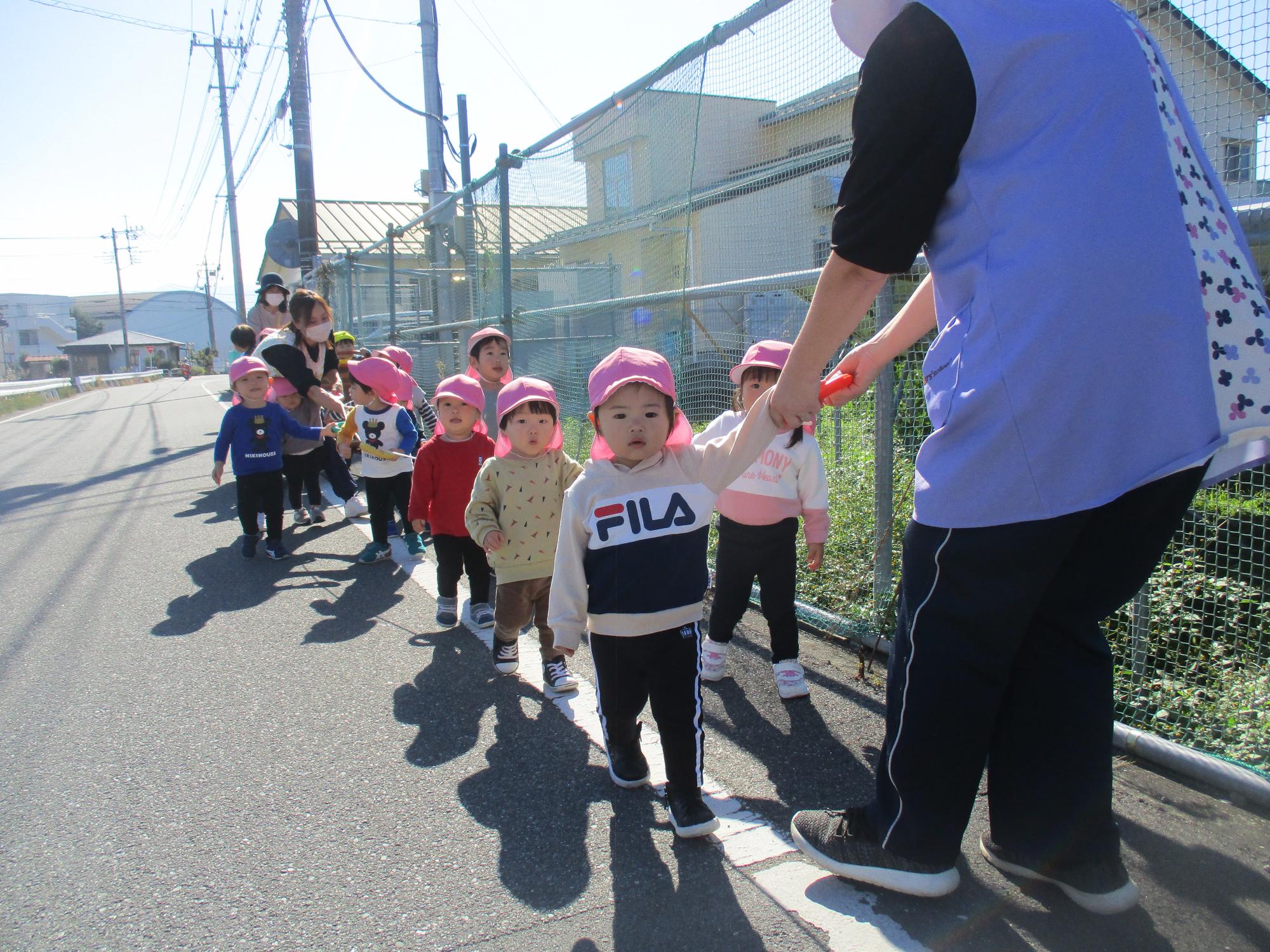 秋の遠足で園周辺を歩くつぼみ1組の子ども達です。