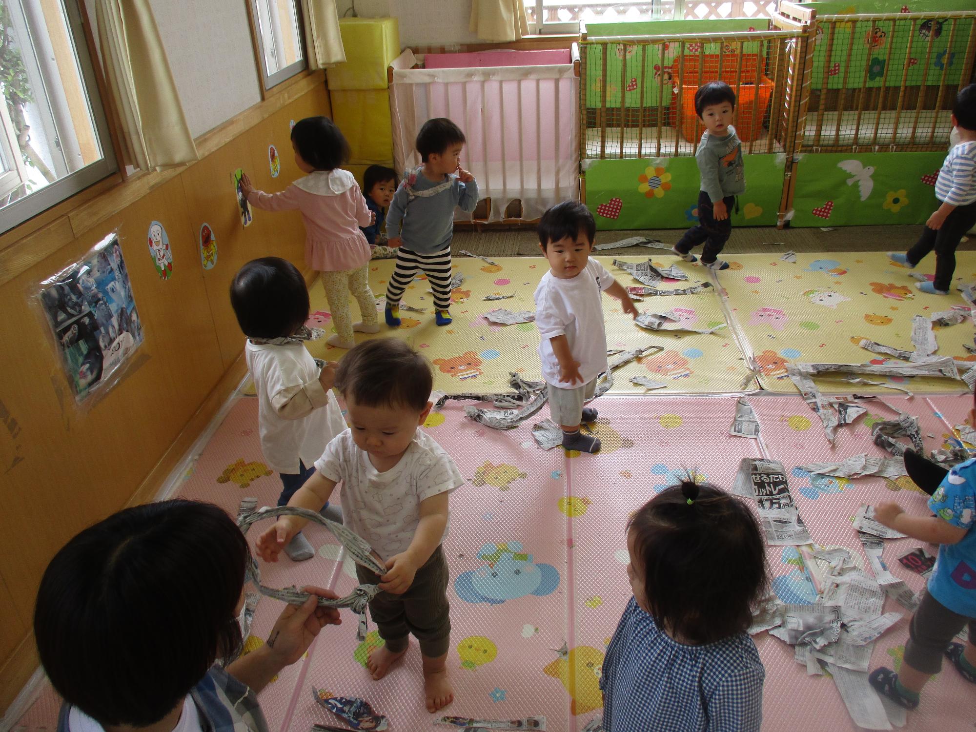 新聞紙遊びを楽しむつぼみ1組の子ども達です。