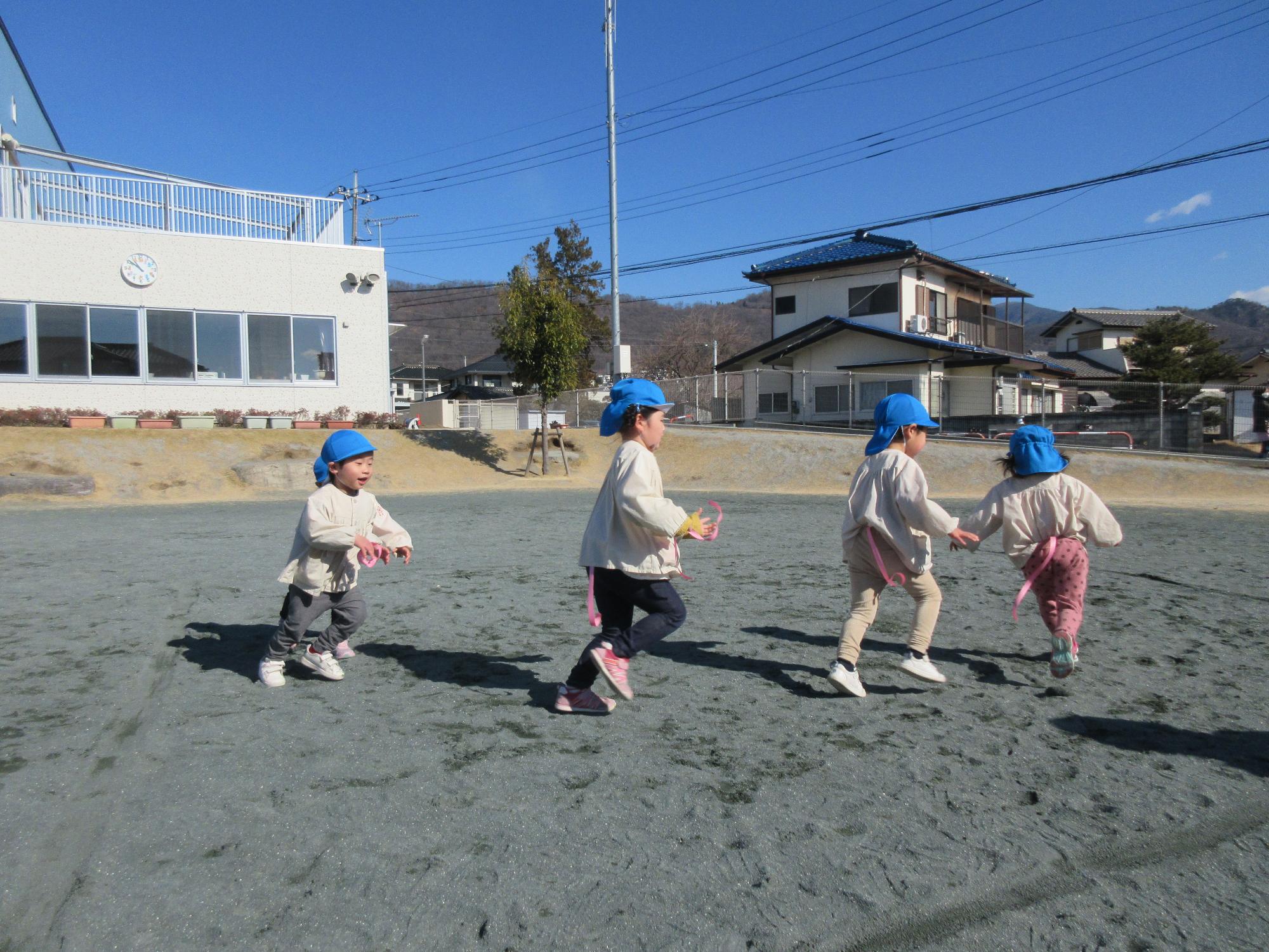 しっぽとりで友だちのしっぽを狙って走っている写真です。