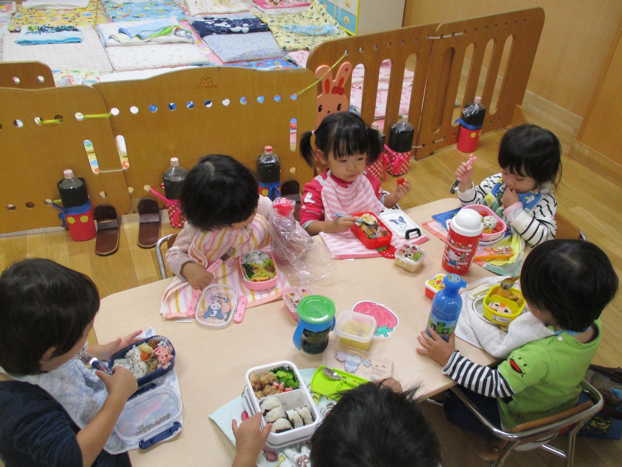 秋の遠足でお母さんが作ったお弁当を楽しむつぼみ1組の様子です。