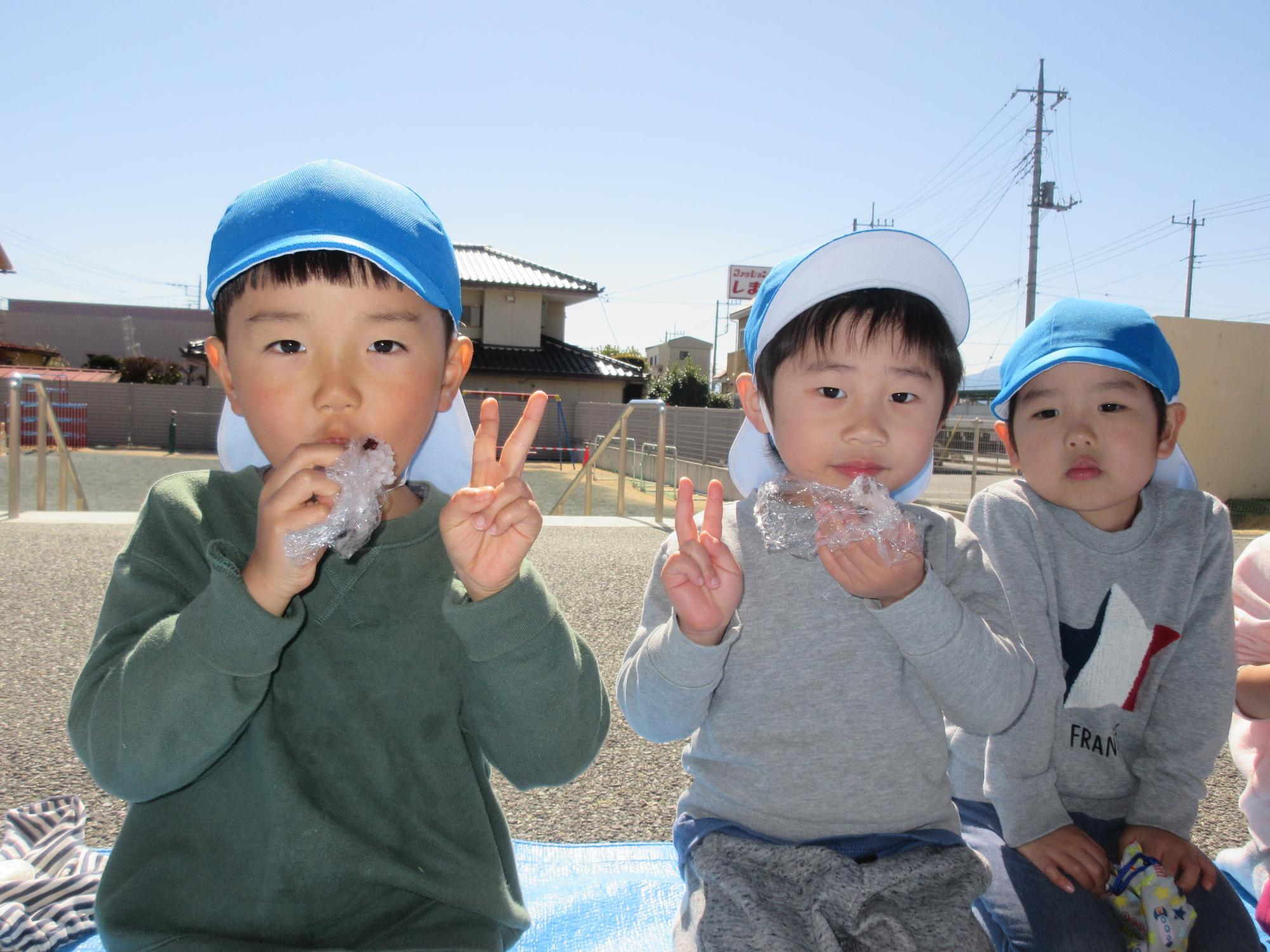 戸外で給食を食べるあお組