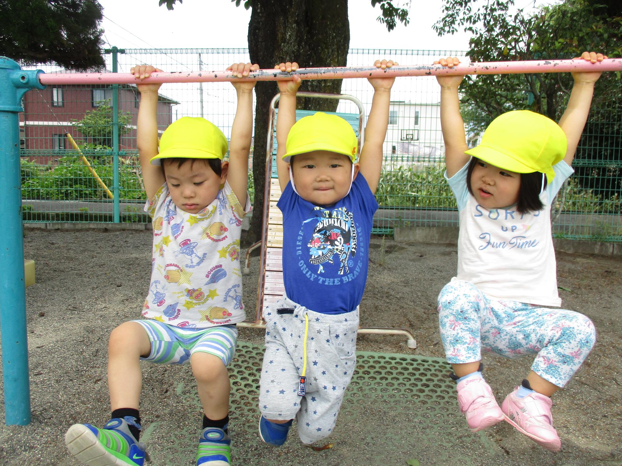 鉄棒にぶら下がるつぼみ2組の子ども達です。