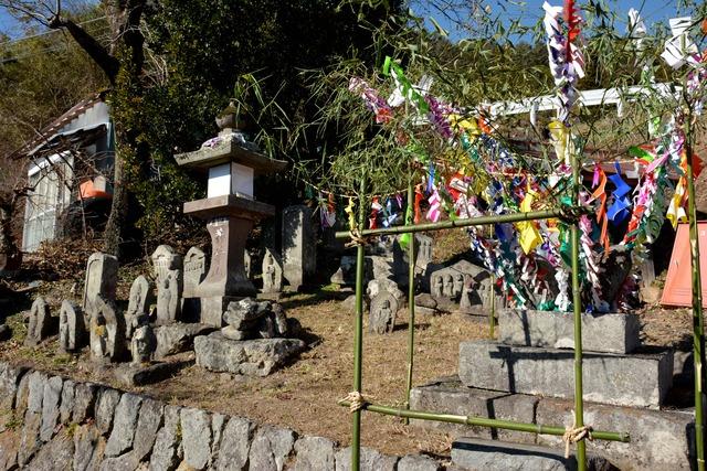 地蔵の周りに色とりどりの飾りがつけられている写真