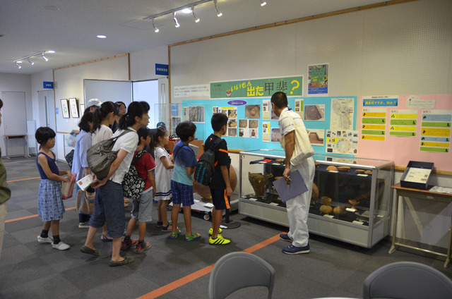 土器を見ながら市学芸員から説明を受ける子ども達の写真