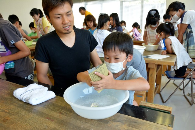 男の子が紙やすりで削っている写真