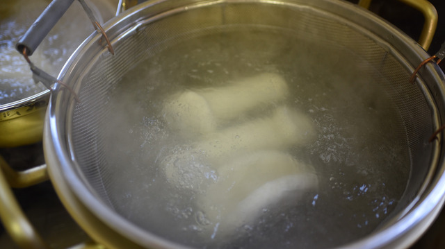 米の粉を練った生地を鍋で茹でている写真
