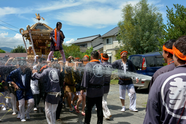 ホースで神輿に水をかけている写真