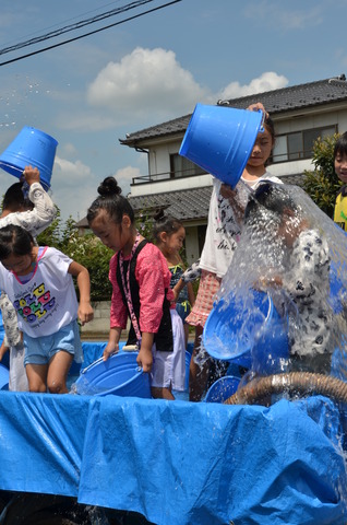 子ども達がバケツで水をかけあっている写真