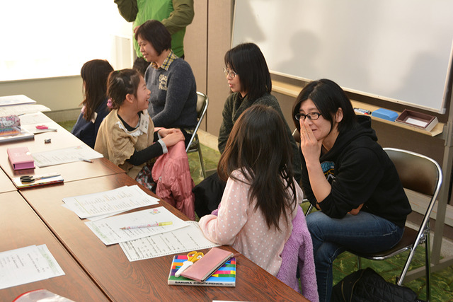 子どもが後ろを振り返り、親子で話し合っている写真