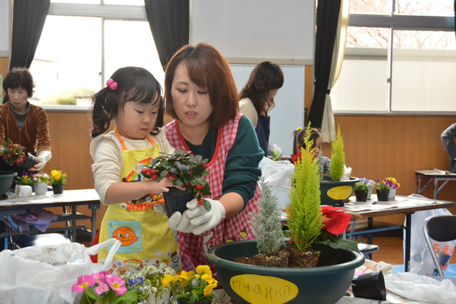 鉢に植物を植えている親子の写真