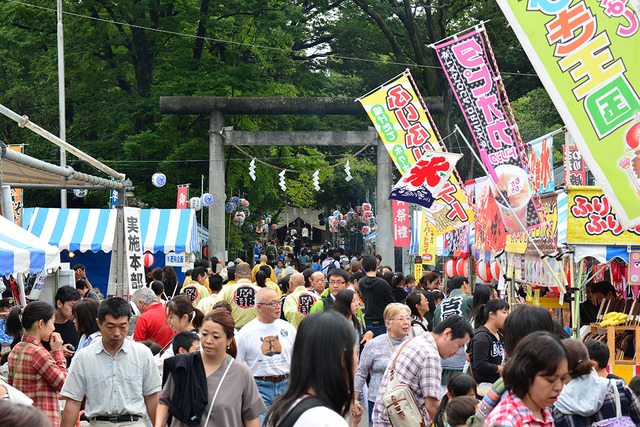 (写真)雨空の中祭りに訪れるたくさんの人々