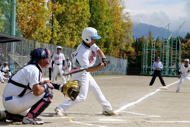 甲斐Aのキャッチャーがボールを掴み、相手チームのバッターが三振した写真