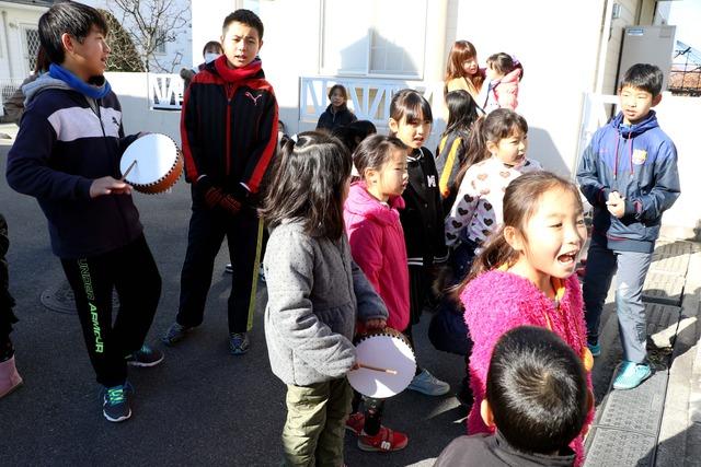 太鼓を持った子ども達が大きな声を出して練り歩く写真
