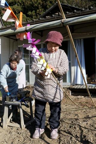 女性が竹に飾りを貼り付けている写真