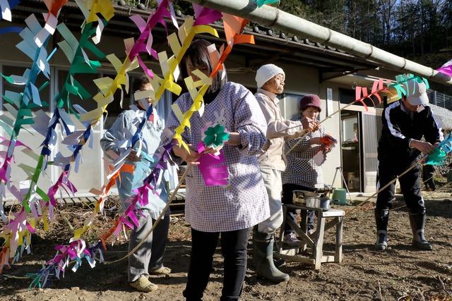 区民が竹の枝飾りを仕上げる写真