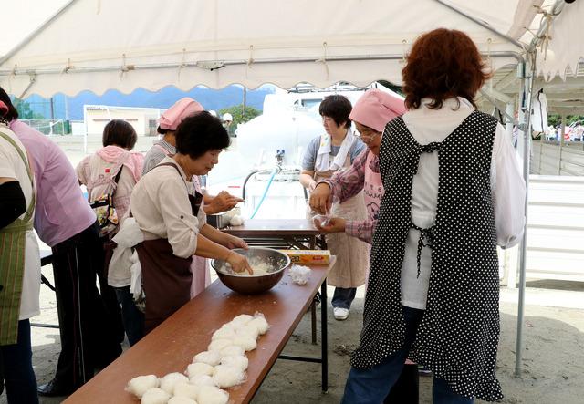 双葉中学校の運動場にて女性の方たちがおにぎりを作っている写真