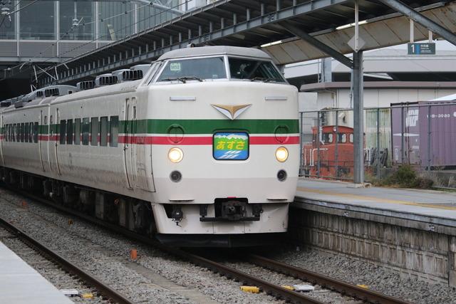 竜王駅を通過する白い車体に緑と赤のラインが入った「臨時特急あずさ号」の写真