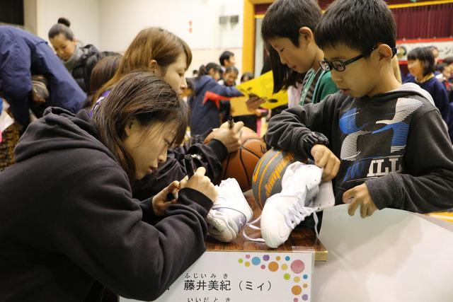 (写真)ボールやシューズにサインをしてもらう来場者たち